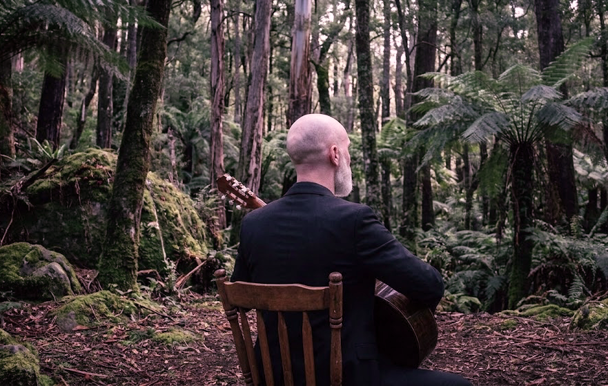 Composer Deo playing classical guitar in the forest